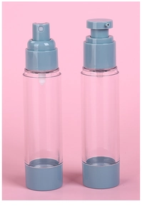 Detail view of transparent spray and lotion vacuum bottles with grey-blue pump heads