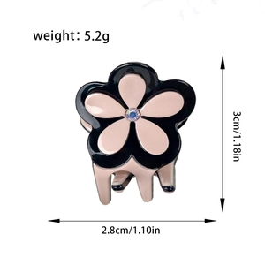 Pince à cheveux fleur en acétate avec pétales noirs et roses et strass central