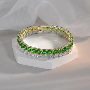 Emerald and white zircon tennis bracelet in 18k gold and silver finish on display