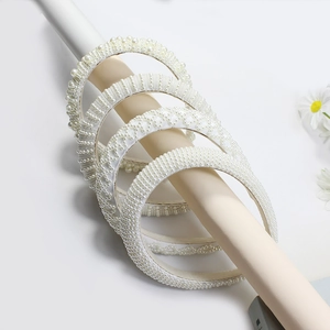 Elegant white pearl headband set with assorted woven designs on display stand