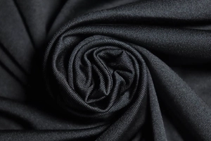 Gros plan sur le tissu en maille noire montrant la texture fine et le drapé souple