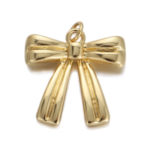 Detail shot of a polished golden bow pendant with a top loop for DIY jewelry making