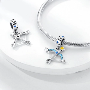 Detailed macro view of silver Sagittarius bow pendant with blue and yellow zircon accents