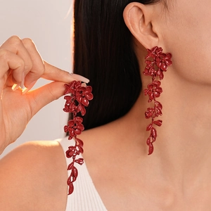 Elegant red enamel flower tassel earrings on model showing aesthetic length and luster