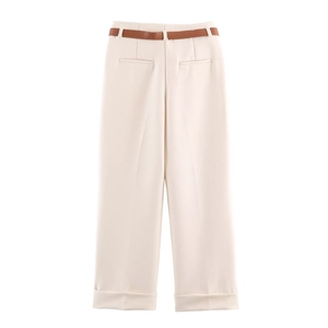 Detail of high-waisted beige wide-leg trousers featuring a brown belt and cuffed hems