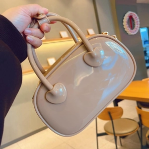 Close-up of beige PVC jelly handbag with glossy finish and heart-shaped handle detail