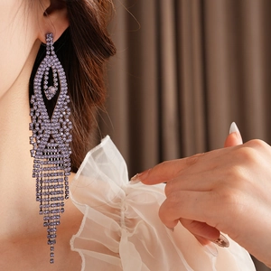 Close-up of long purple rhinestone tassel earrings worn by a model in waterfall style