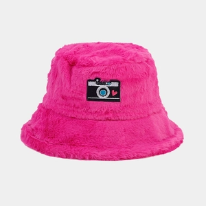 Close-up of rose pink faux fur bucket hat with a camera heart patch and plush texture