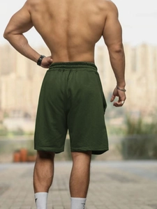 Close-up of the back view of dark green breathable cotton shorts for men in outdoor setting
