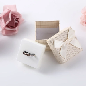 Square ribbon ring box with black and rose gold diamond ring and pink rose decoration