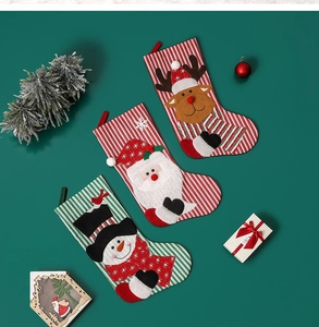 Three festive Christmas stockings with Santa, snowman and reindeer embroidery on green backdrop
