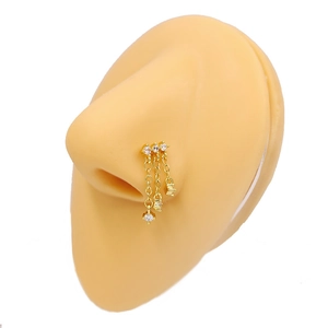 Détail d'un piercing de nez en or avec zircon en cœur et trois breloques sur modèle