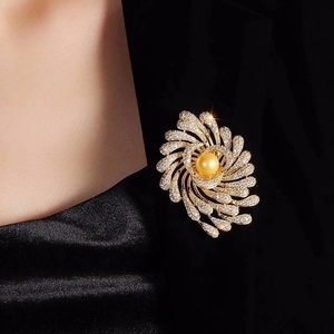 Close-up of luxury gold firework brooch with crystals on black suit lapel