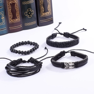 Vue détaillée d'un ensemble de quatre bracelets en cuir noir avec un pendentif hibou argenté