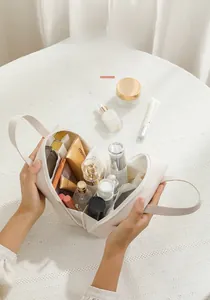 Detail of creamy white PU leather shell makeup bag with multi-compartment interior