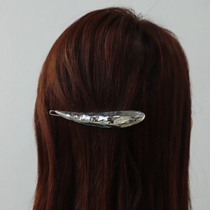 Lava geometric metal hair claw clip in silver fish shape on female model hair
