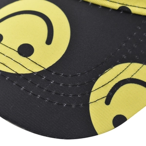 Close-up of baseball cap brim featuring yellow smiley face pattern and reinforced stitching