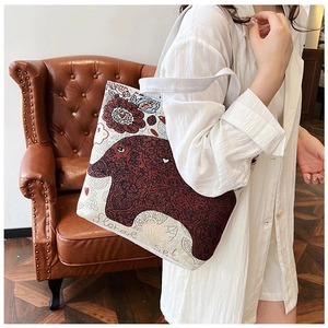 Detail shot of ethnic canvas tote bag featuring red elephant embroidery and floral patterns