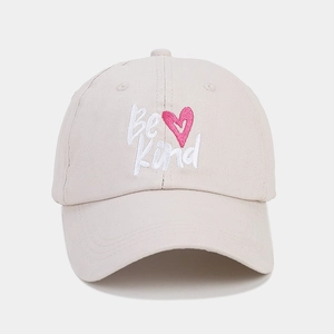 Close-up of Be Kind embroidery with a pink heart on a beige twill cotton baseball cap