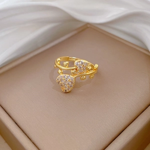 Detail of gold heart ring with pavé zircons and vine design on a satin jewelry box