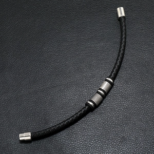 Detailed macro view of black braided PU leather bracelet with magnetic alloy clasp