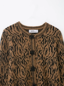 Close-up of leopard knit cardigan with round neck and black beaded floral buttons
