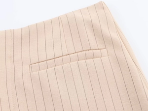 Gros plan du tissu à rayures fines et détail de poche passepoilée sur jupe-culotte