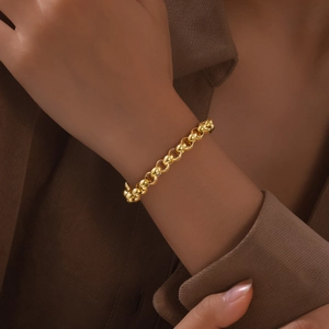 Detail of a gold OT buckle pearl bracelet on a model's wrist with classic round links