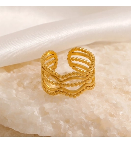Detailed view of multilayer wavy gold beaded ring on elegant satin silk background