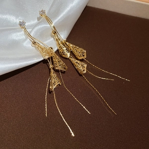 Detail of 18K gold plated drop earrings with hollow cones and long delicate metal tassels