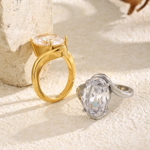Detailed view of 18K gold and silver plated rings with oval cubic zirconia in claw setting