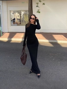 Élégante robe longue noire ajustée à manches longues avec un design chic à l'épaule