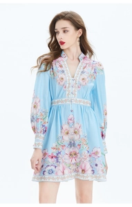 Détail de la robe florale bleu clair avec manches bouffantes et design boutonné en V