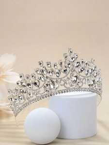 Detail of silver bridal crown with sparkling rhinestones on a white display stand