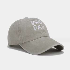 Macro detail of DOG DAD embroidery and washed cotton fabric on light khaki baseball cap