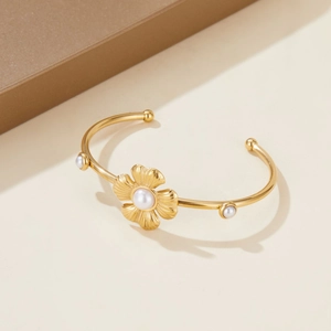 Elegant gold-tone stainless steel open bangle with flower motif and white pearls