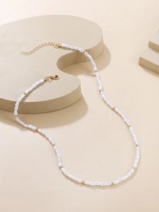 Close-up of baroque pearl necklace with gold beads and lobster clasp on display
