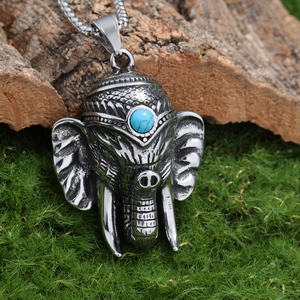Gros plan détaillé du pendentif éléphant avec pierre turquoise sur mousse et fond bois