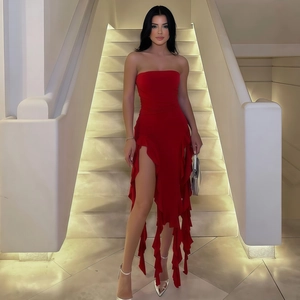 Detail of red strapless dress featuring high slit and irregular ruffled hemline accents