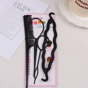 Detail of 4pcs black plastic hair styling set with comb and tail tools on white fabric