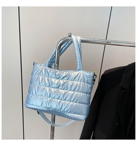 Detailed view of light blue quilted space cotton handbag with shiny metallic finish