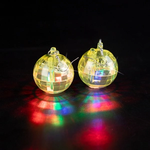 Close-up of LED disco ball earrings glowing with red and blue light on reflective surface