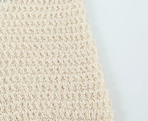 Macro detail showing high-density beige crochet knit texture and intricate weave patterns