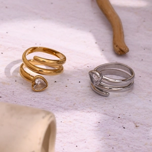 Detail of 18K gold and silver spiral rings featuring heart-shaped crystal settings