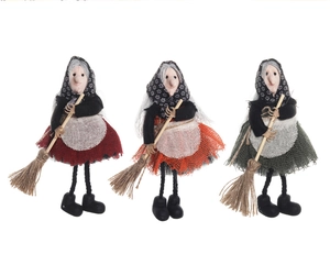 Detailed view of handmade Halloween witch dolls in red, orange, and green skirts with brooms