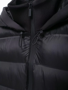 Detailed view of black puffer jacket featuring high-quality metal zipper and adjustable hood cords