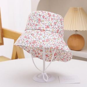 Detailed view of floral pattern kids sun hat with adjustable white chin strap on stand