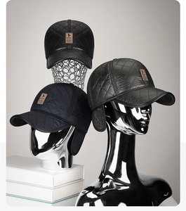 Close-up of quilted winter baseball caps with ear flaps in black, grey and navy blue