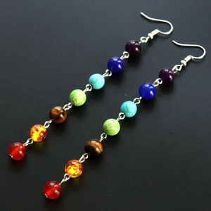 Detailed view of colorful natural stone chakra beads on silver dangle earrings