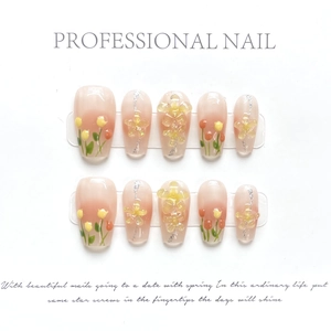 Detailed press-on nails with pink gradient and 3D floral art on display stands